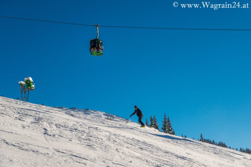 Snowboarder unter der Flying Mozart Gondel in Wagrain